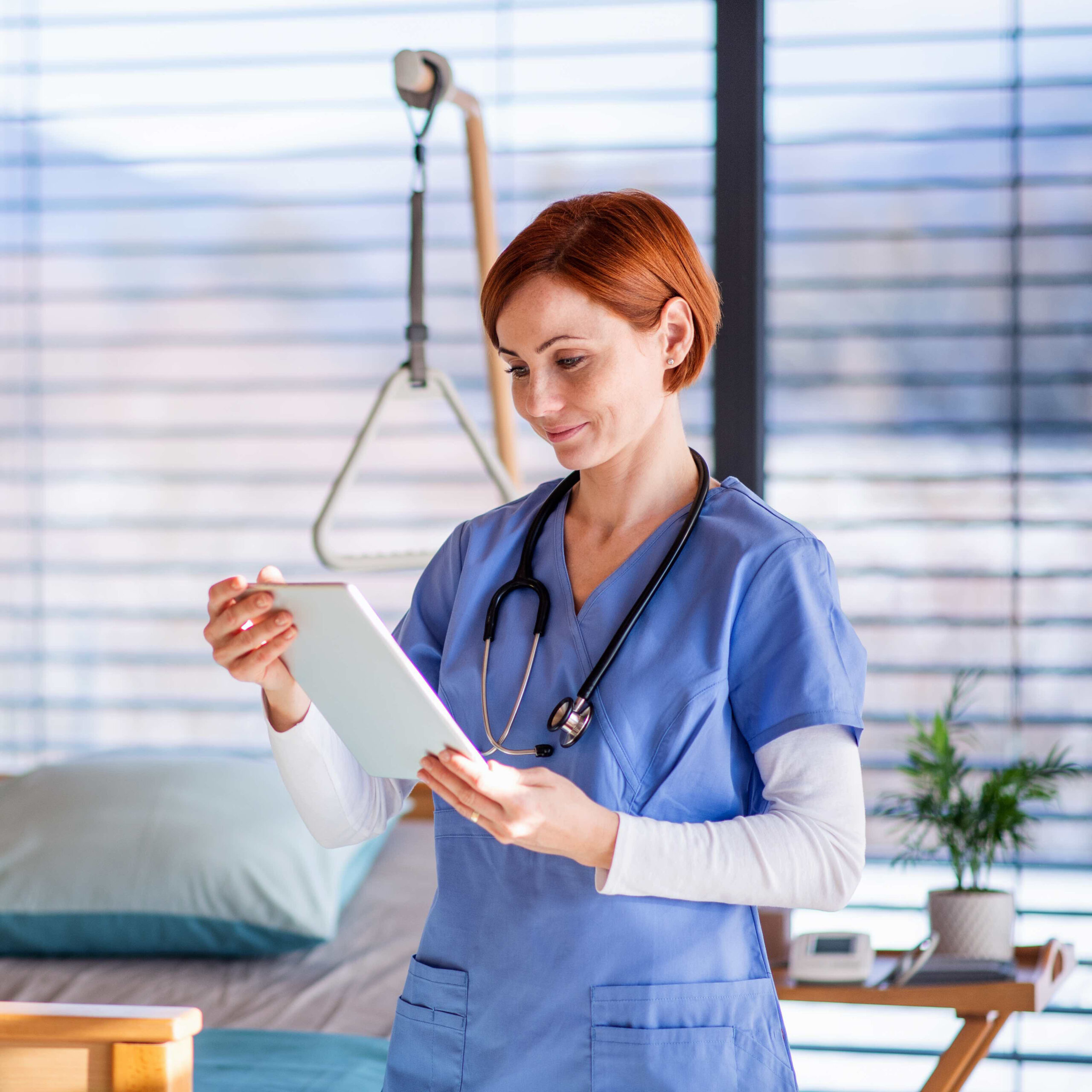 woman in scrubs checking a tablet
